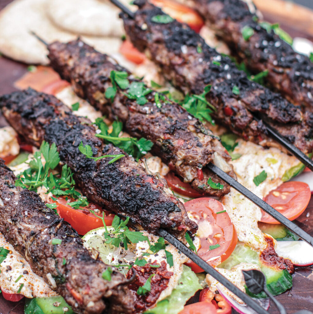 A fragrant and spiced lamb kofta, cooked over open flames, served with a cooling harissa yogurt and fresh Greek-style salad. A perfect side dish for your next Kadai gathering.