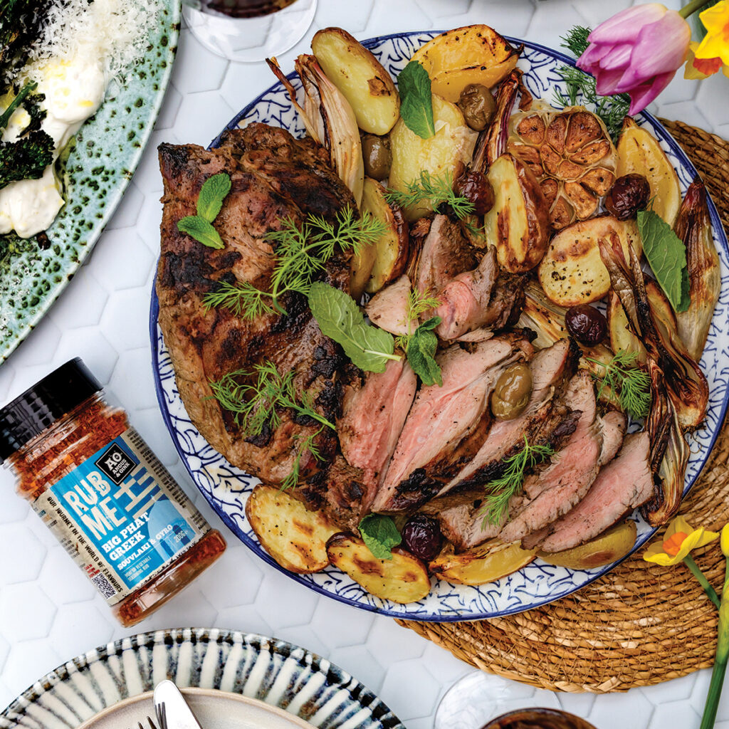 A butterflied leg of lamb, marinated overnight in lemon, olive oil, and Greek seasoning, is grilled low and slow until blushing pink, then rested and sliced alongside a showstopping traybake of caramelised potatoes, charred lemon wedges, and roasted olives. Chargrilled tenderstem broccoli on a cloud of lemony ricotta rounds out a feast that's effortlessly celebratory and built for sharing.