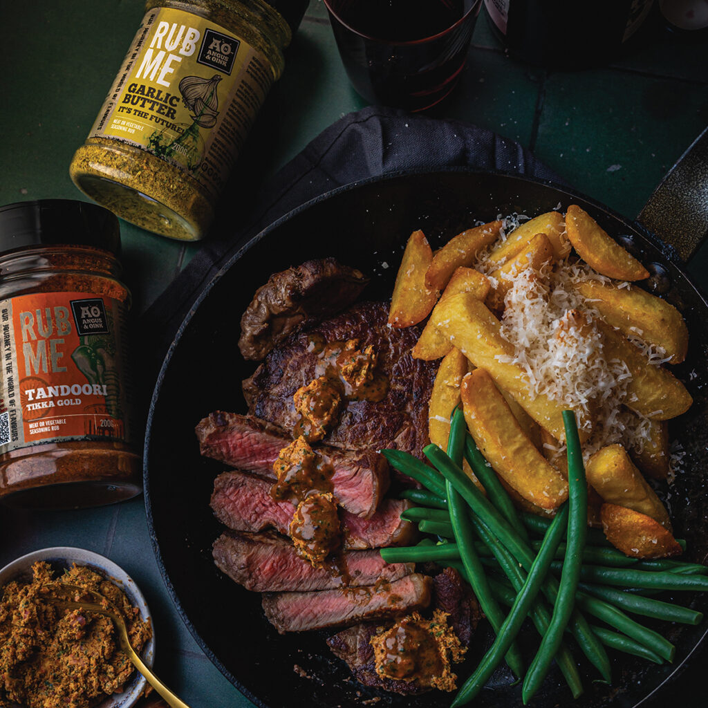 Nick Hook keeps it classic with seared sirloin steaks and a Café de Paris butter loaded with anchovies, capers, Worcestershire, fresh herbs and a kick of Tandoori seasoning that one slice melting over a resting steak is all the sauce you'll ever need. Simple to cook, impossible to forget — and served, as Nick insists, with truffle-oil chips buried under a blanket of Parmesan.