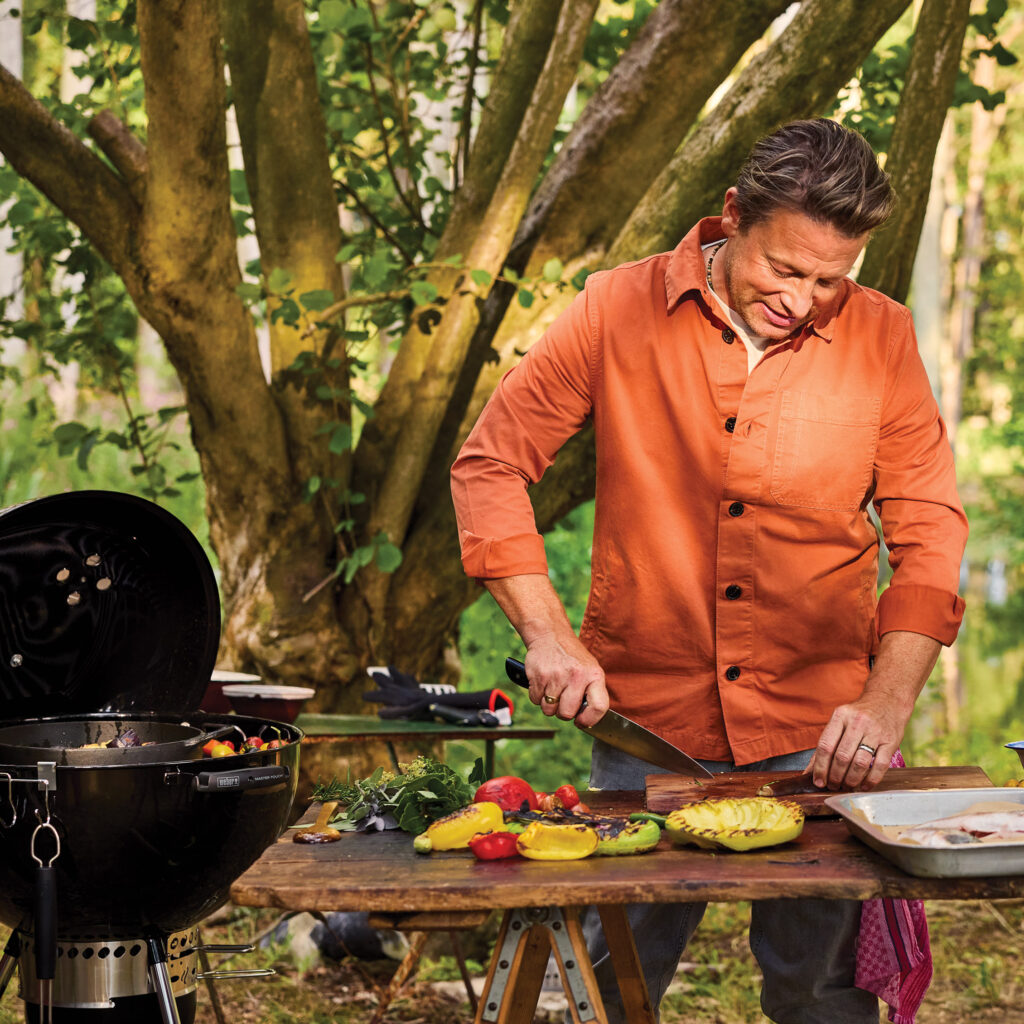 A TV series all about BBQ; a book all about BBQ.  Jamie Oliver has cooked just about everything everywhere, but outside over the grill is the chef’s happy place. RUPERT BATES reports